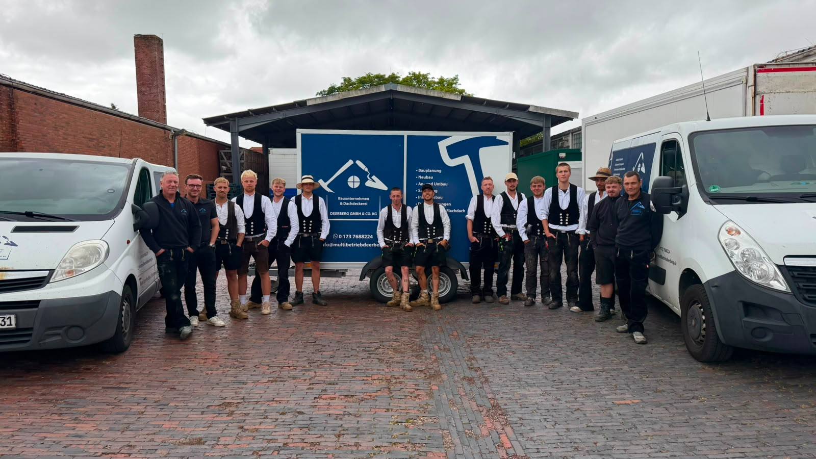 Team der Dachdeckerei Deerberg vor den Firmenfahrzeugen